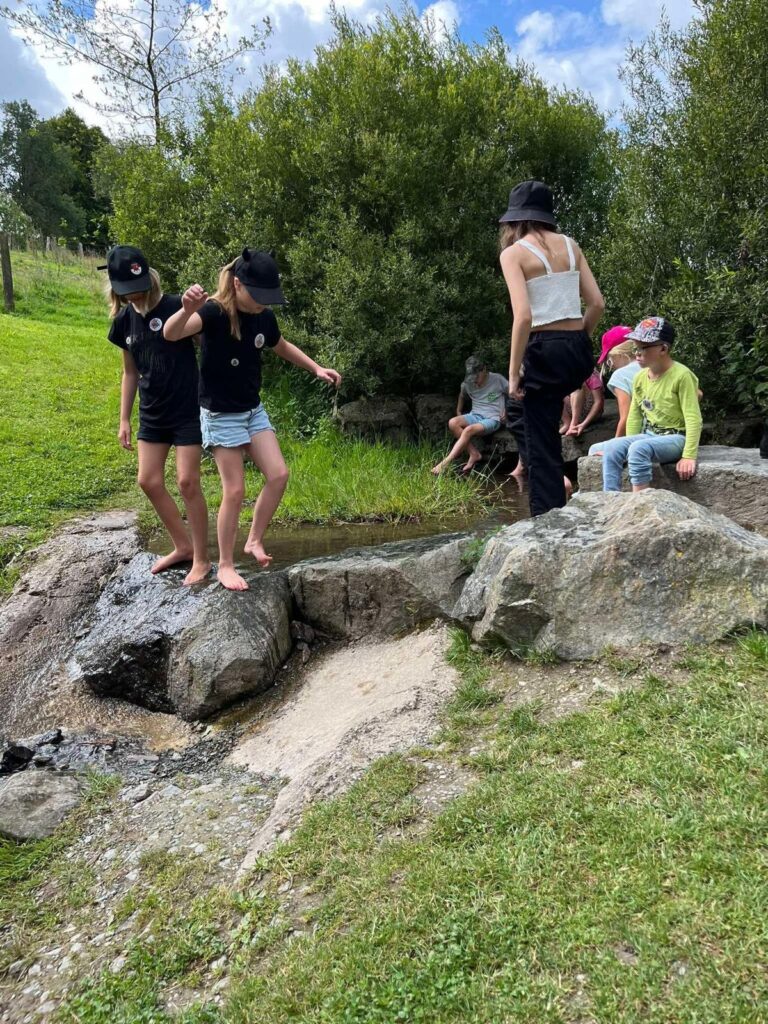 Kinder spielen bei einem Ausflug an einem Bachlauf