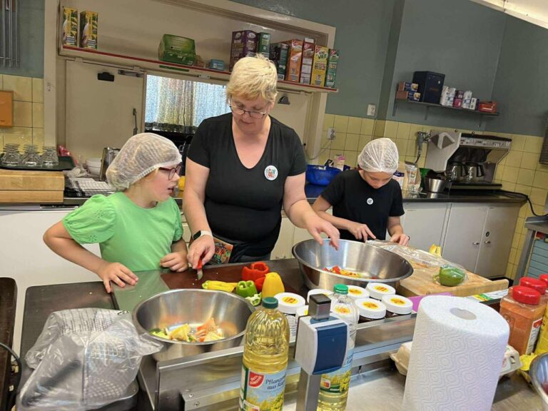 Ehrenamtliche bereiten in der Küche gemeinsam frisches Essen zu